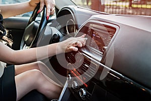 Female hand tuning radio in car, closeup