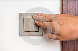 Female hand is turning on or off interior light switch
