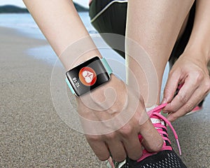 Female hand tying shoelaces wearing bright green watchband touch