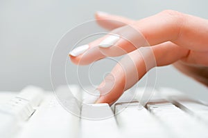 Una mujer mano escribiendo sobre el computadora teclado 