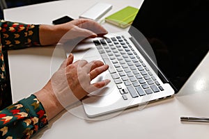 Female hand typing keyboard on laptop. Unrecognizable elegant woman working on computer at office. Start or finish of a
