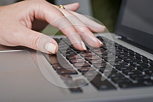 Female hand typing on a laptop keyboard