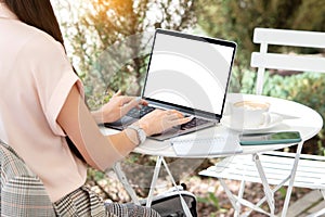 Female hand typing in the laptop with mockup empty white screen for your text, creative design or advertisement