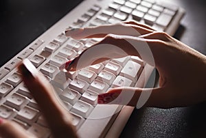 Female hand typing on the white keyboard