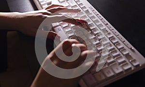 Female hand typing on the white keyboard