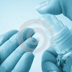 Female hand use sanitizer gel from a small plastic bottle