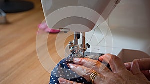 Female hand using sewing machine stitching fabic
