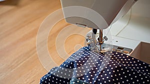 Female hand using sewing machine stitching fabic
