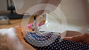 Female hand using sewing machine stitching fabic