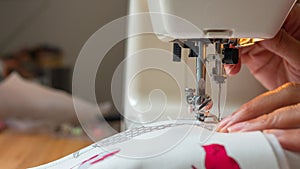 Female hand using sewing machine stitching fabic