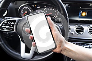 Female hand using smartphone in car. Smartphone in a car use for Navigate or GPS. Mobile phone with isolated white screen. Blank