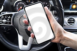Female hand using smartphone in car. Smartphone in a car use for Navigate or GPS. Mobile phone with isolated white screen. Blank