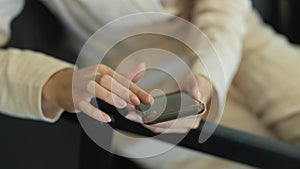 Female hand using smartphone while relaxed sitting in offic eroom