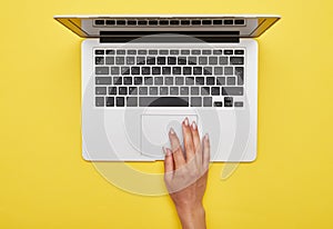 Female hand using touchpad of laptop