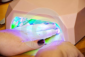 Female hand in UV Gel Acrylic Dryer