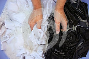 Female hand wash black and white clothes