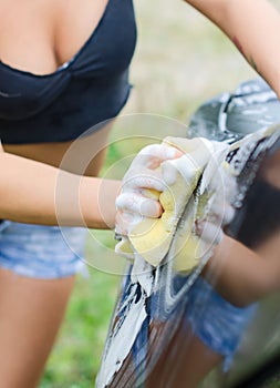 Female hand washing car.