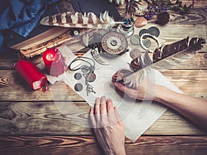 Female hand writes the letter with feather quill pen.