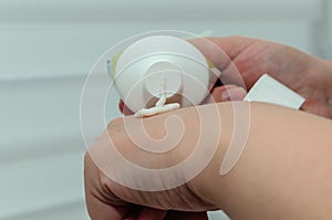 Female hands applying cream from a tube to her hands