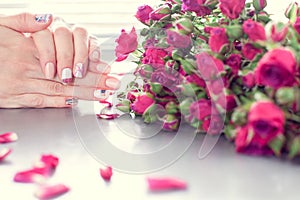 Female hands with art nail manicure and small pink roses