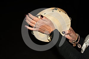 female hands banging the tambourine