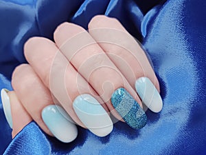 Female hands beautiful manicure, stylish texture, design gradient silk fabric