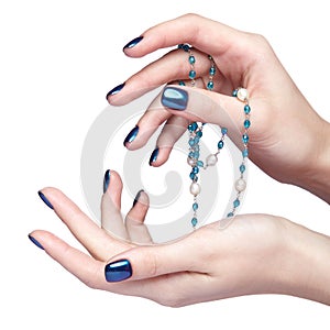 Female hands with bijouterie beads and shiny nails manicure isolated on white