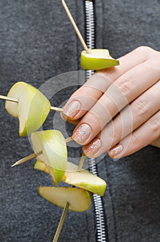 Female hands with blue glitter nail design.