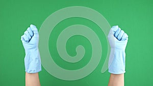 Female hands with blue protective rubber gloves clench and unclench their fingers over green chromakey background. 4k