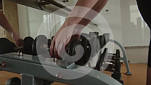 Female hands, bodybuilding, dumbbells in the gym. Closeup woman's hands taking weight lifting in sport club. Fitness