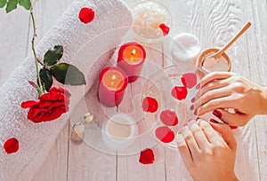 Female hands in bowl with rose water. Skincare and spa concept