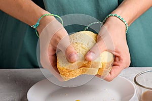 female hands breaking a sandwich with honey and peanut butter of wheat bread to have breakfast