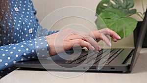 Female hands of a business woman working on computer. Student girl typing text on laptop keyboard. Woman sitting at home