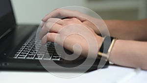 Female hands of a businesswoman professional user-an employee typing on a laptop keyboard, sitting at a table, a student