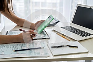 Female hands with calculator above 1040 tax form