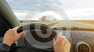 Female hands on car steering wheel, drivers pov