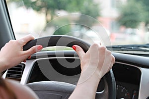 Female hands on a car wheel