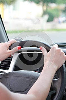 Female hands on a car wheel