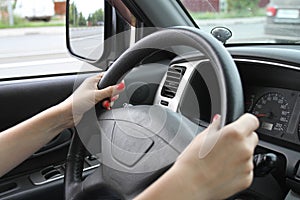 Female hands on a car wheel