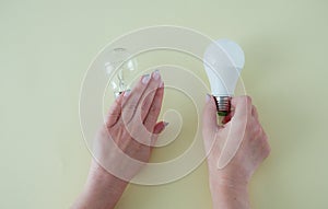 Female hands choose an LED bulb instead of an incandescent bulb. Energy saving. Concept