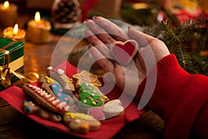 Female hands with christmas gift and homemade gingerbread cookie