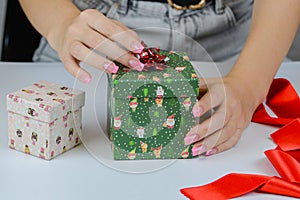 female hands close-up packing Christmas gifts, handmade, Christmas decor on the table