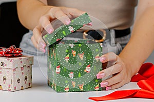 female hands close-up packing Christmas gifts, handmade, Christmas decor on the table