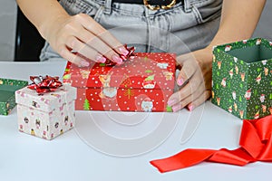 female hands close-up packing Christmas gifts, handmade, Christmas decor on the table