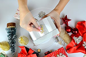 female hands close-up packing Christmas gifts, handmade, Christmas decor on the table