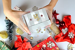 female hands close-up packing Christmas gifts, handmade, Christmas decor on the table