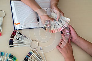 Female hands and colorful nail polish palette.