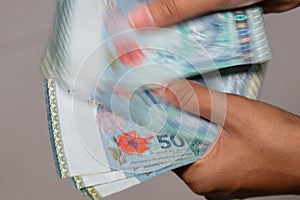 Female hands counting malaysian Ringgit. Human hands holding RM50