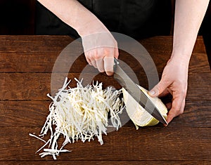 Female hands cut with a knife cabbage