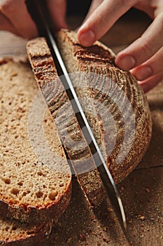 Female hands cutting bread